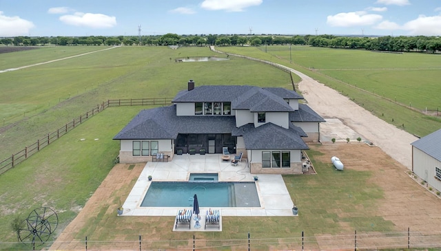 14402 Stice Rd, Krum, TX 76249 - back of property with a view of countryside, roof with shingles, a patio, a pool with connected hot tub, and a chimney