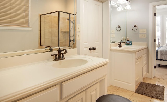 bathroom with a stall shower, a sink, and tile patterned floors