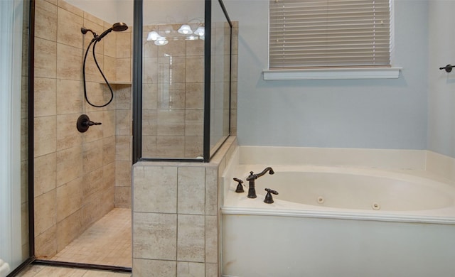 bathroom featuring a tub with jets and tiled shower