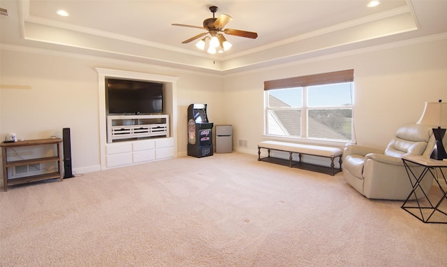 living area featuring carpet, a raised ceiling, and crown molding