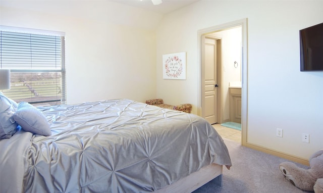 bedroom with light carpet and connected bathroom