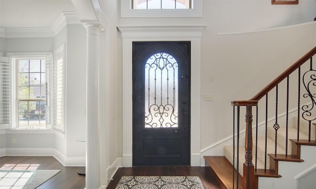 entrance foyer featuring crown molding, dark wood finished floors, decorative columns, stairway, and baseboards