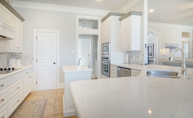 kitchen with stainless steel appliances, crown molding, white cabinetry, a sink, and light tile patterned flooring