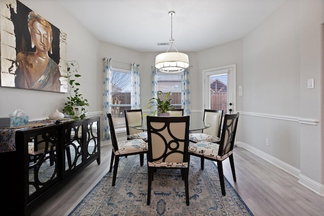 dining area featuring wood finished floors, visible vents, and baseboards