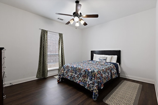 bedroom with visible vents, baseboards, and wood finished floors