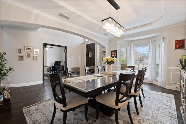 dining room with arched walkways, a notable chandelier, visible vents, dark wood finished floors, and crown molding