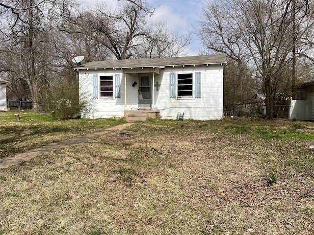 view of front of property with fence and a front lawn