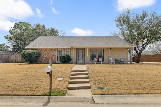 single story home with roof with shingles, a front yard, and fence