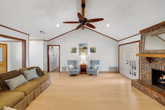 living area with a brick fireplace, visible vents, and vaulted ceiling