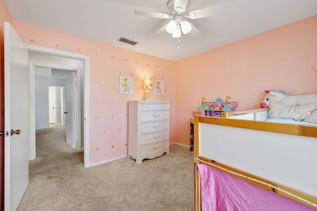 bedroom featuring baseboards, visible vents, and light colored carpet