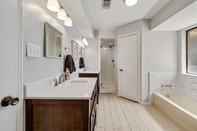 full bathroom featuring a garden tub, visible vents, a stall shower, vanity, and wood finished floors