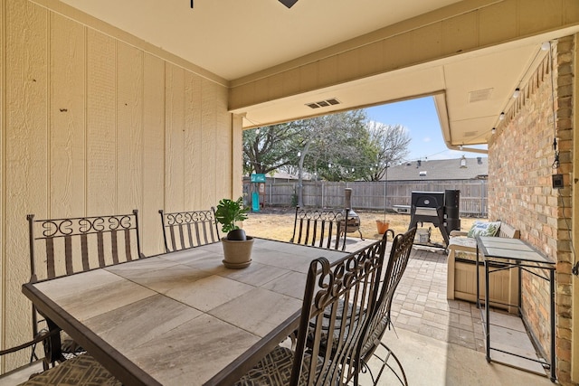 view of patio with outdoor dining area, visible vents, and a fenced backyard