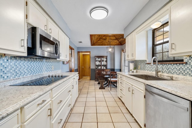 kitchen featuring light tile patterned floors, white cabinetry, stainless steel appliances, and a sink