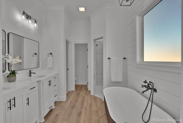 bathroom with double vanity, a freestanding bath, toilet, a stall shower, and a sink