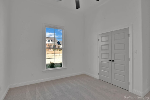 spare room featuring ceiling fan, baseboards, and carpet flooring