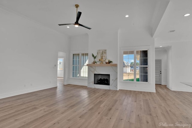 unfurnished living room with a wealth of natural light, wood finished floors, and a premium fireplace