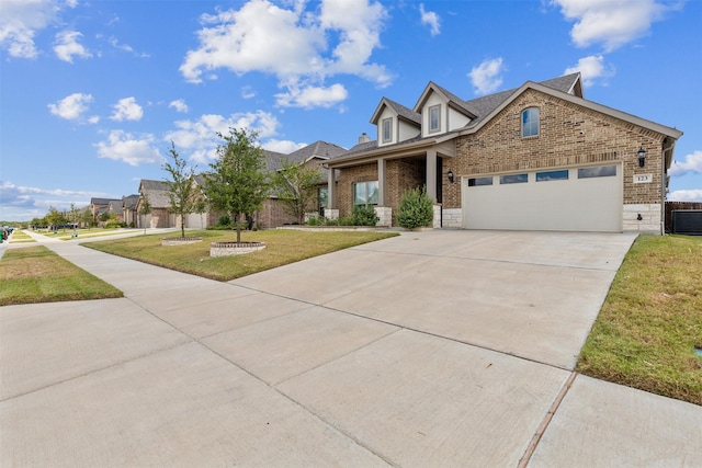 view of front of house featuring a garage, brick siding, driveway, stone siding, and a front yard