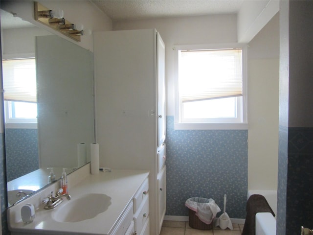 bathroom with wallpapered walls, plenty of natural light, a textured ceiling, and tile patterned flooring