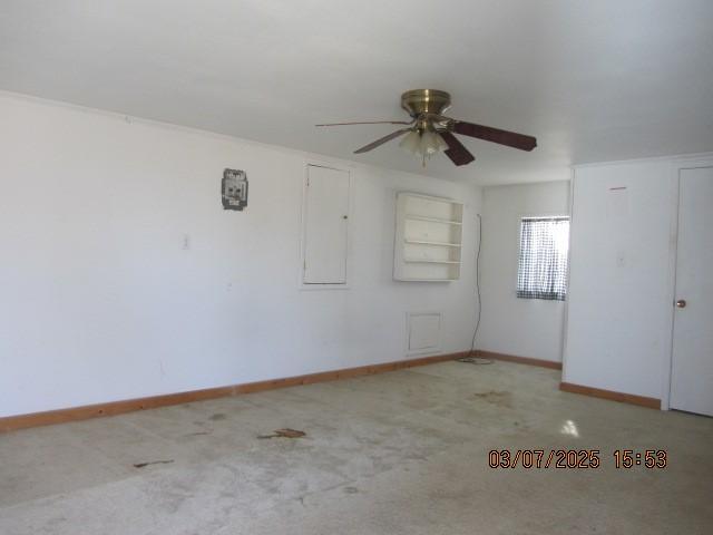 empty room featuring a ceiling fan and baseboards