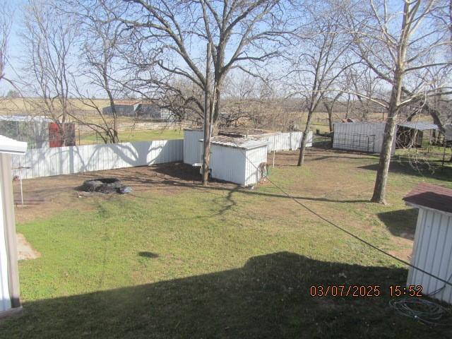 view of yard featuring an outbuilding, a shed, and a fenced backyard