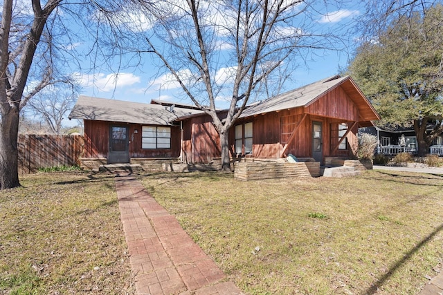 view of front of property with a front yard, fence, and entry steps