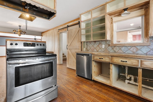 kitchen with a barn door, refrigerator, stainless steel electric range, tasteful backsplash, and dark wood finished floors