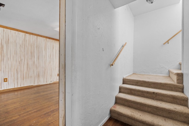 stairway with wood-type flooring and baseboards