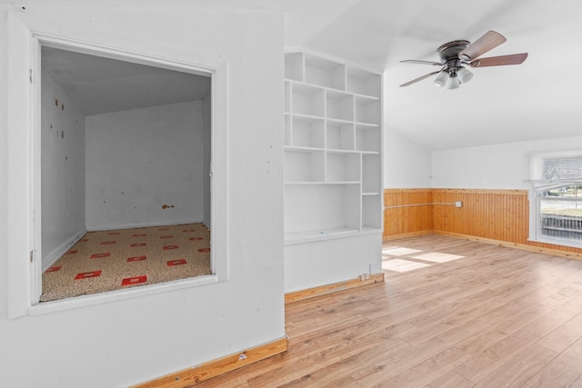 interior space featuring built in features, wainscoting, ceiling fan, and wood finished floors