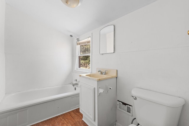 bathroom with visible vents, toilet, wood finished floors, vanity, and tile walls