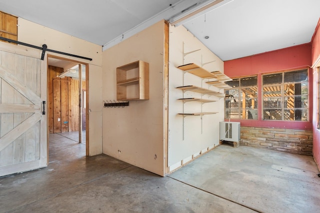 interior space featuring concrete flooring and a barn door