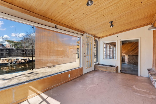 unfurnished sunroom featuring lofted ceiling and wood ceiling