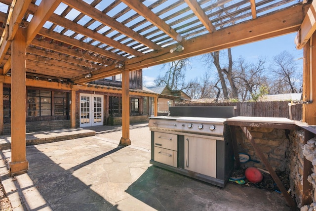 view of patio featuring fence, a pergola, exterior kitchen, and french doors