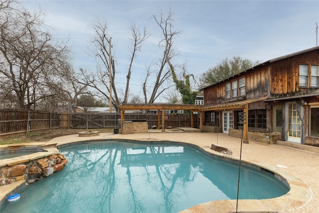 view of pool featuring a pool with connected hot tub, a fenced backyard, and a patio