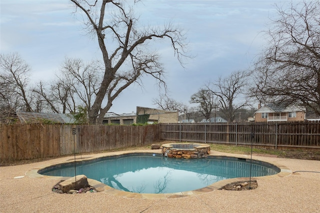 view of swimming pool featuring a fenced backyard and a pool with connected hot tub