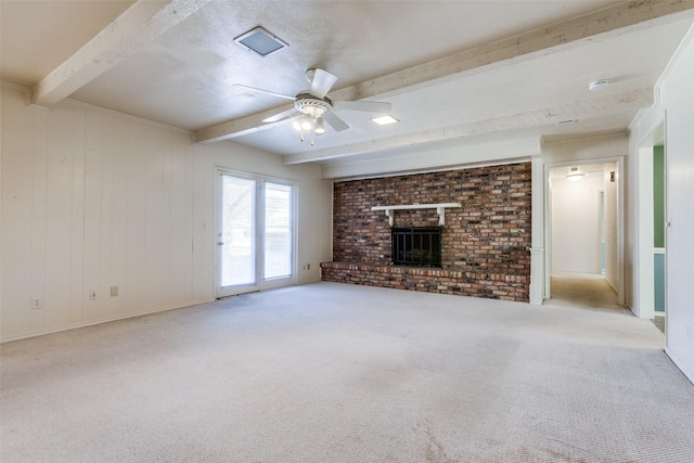 unfurnished living room featuring carpet floors, a fireplace, a ceiling fan, and beam ceiling