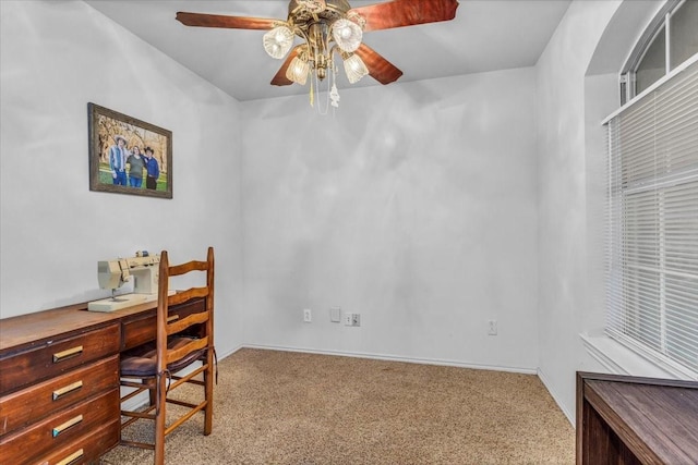 carpeted office with a ceiling fan