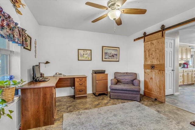 home office with a barn door and a ceiling fan