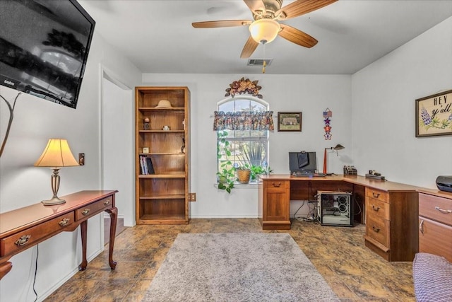 home office featuring stone finish floor, visible vents, and a ceiling fan