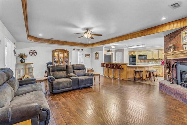 living room featuring ceiling fan, hardwood / wood-style flooring, and visible vents