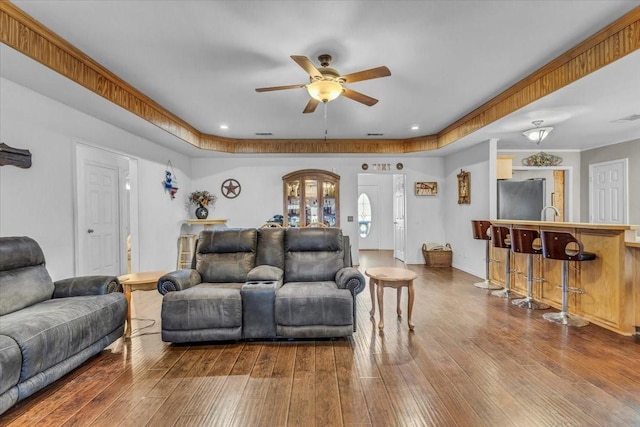 living room featuring visible vents, dark wood-type flooring, a ceiling fan, and baseboards