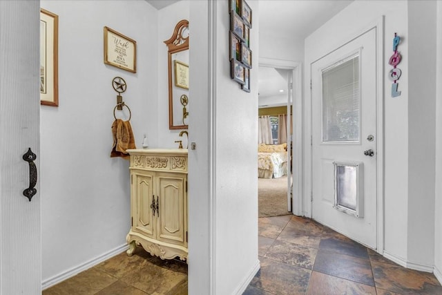 interior space featuring stone finish flooring and baseboards