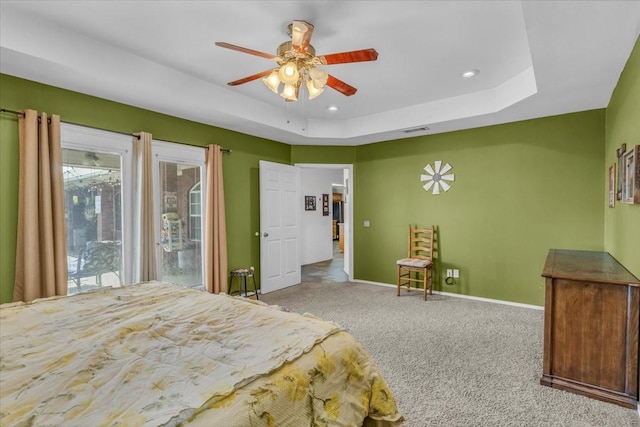 carpeted bedroom featuring visible vents, baseboards, a ceiling fan, a tray ceiling, and recessed lighting