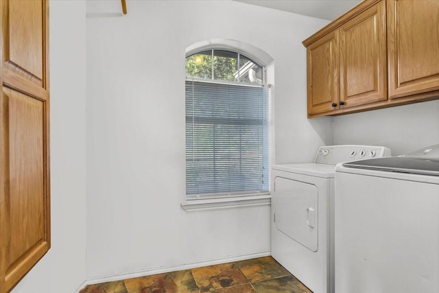 laundry area with cabinet space, stone finish floor, and independent washer and dryer