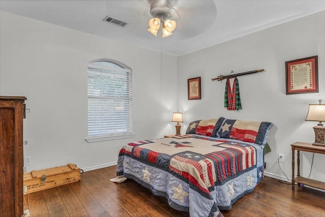 bedroom featuring wood-type flooring, visible vents, ceiling fan, and baseboards