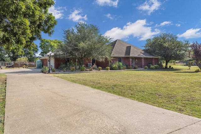 single story home featuring a front yard, brick siding, and driveway