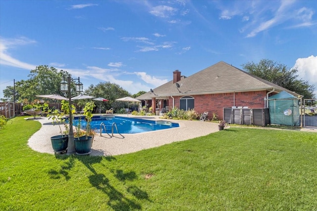 pool with a yard, fence, and a patio