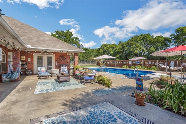 view of pool with a fenced in pool, french doors, a patio area, and a fenced backyard