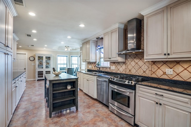 kitchen featuring visible vents, appliances with stainless steel finishes, wall chimney range hood, and a sink