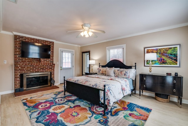 bedroom featuring multiple windows, a fireplace, wood finished floors, and ornamental molding