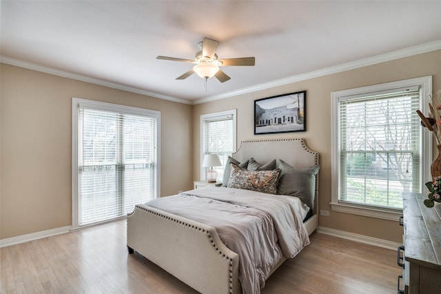 bedroom featuring multiple windows, light wood-style floors, and baseboards